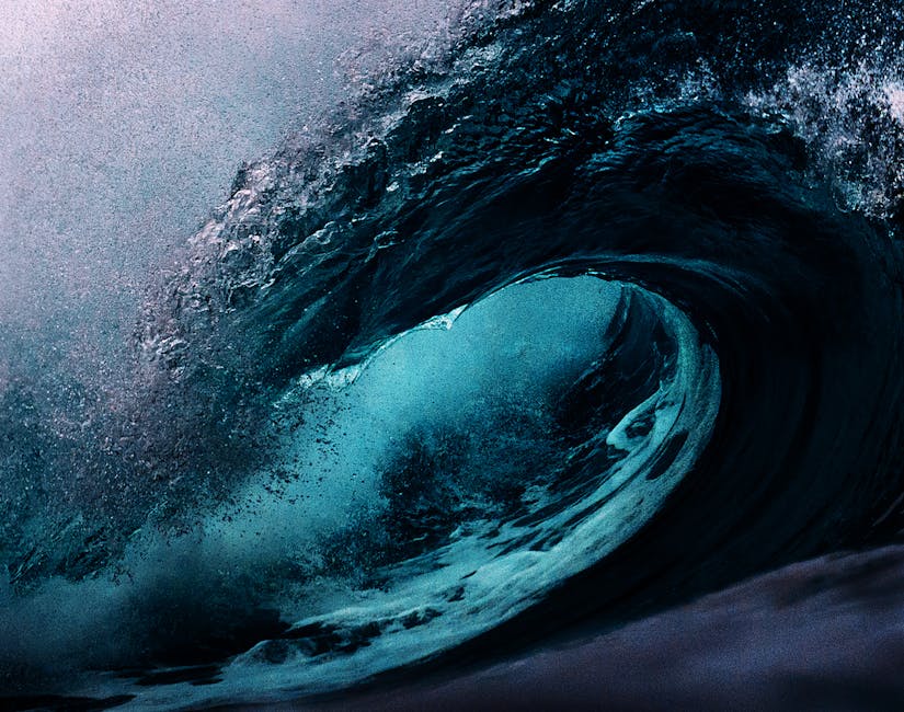 Dramatic capture of a powerful ocean wave with dark blue tones.